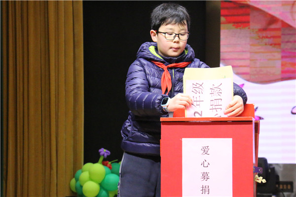 4   二年级学生代表将善款投入爱心募捐箱.jpg